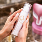Model Holding Lumiere Skyn Cleanser With Both Hands And HyperGlo In The Background